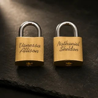 Two personal engraved brass padlocks on slate